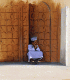 Omani boy in shaded doorway